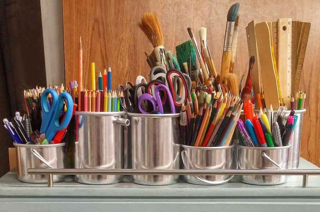 Tin cans filled with pencils, pens and paintbrushes